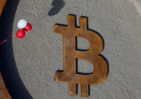 People attend the opening ceremony of world's first public Bitcoin monument, placed at a roundabout connecting two roads at the city centre in Kranj, Slovenia, March 13, 2018. REUTERS/Borut Zivulovic