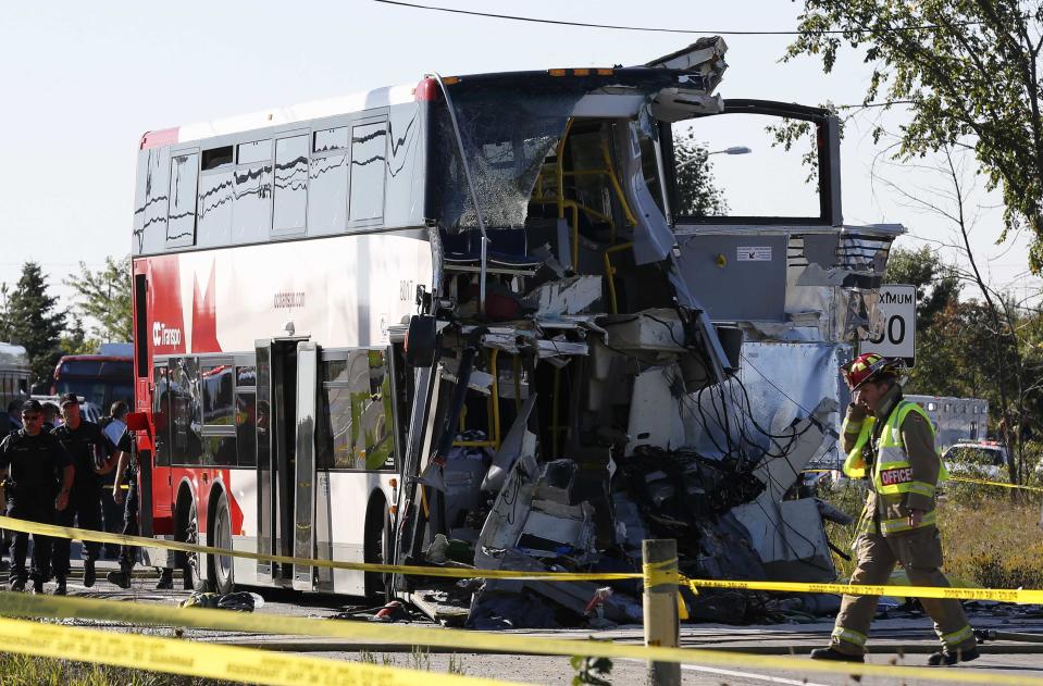 A firefighter walks in front of the scene of an accident involving a bus and a train in Ottawa