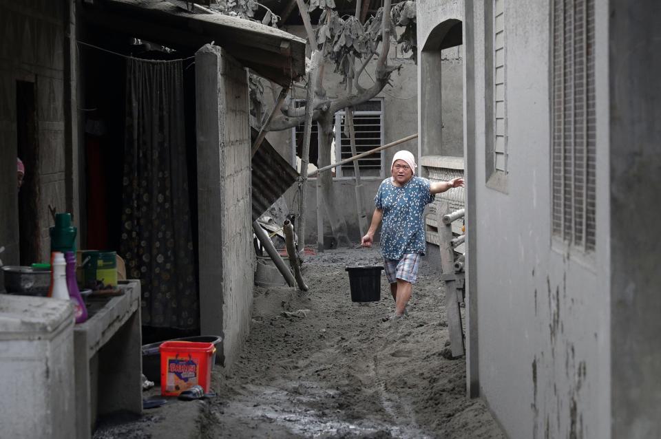 A resident fetches water at their volcanic ash covered village in Laurel, Batangas province.