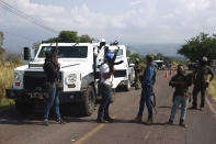 Members of the so-called self-defense group known as United Towns or Pueblos Unidos, block a road as they gather for a rally in Nuevo Urecho, in the Mexican western state of Michoacan, Saturday Nov. 27, 2021. Extortion of avocado growers in western Mexico has gotten so bad that 500 vigilantes from the "self-defense" group gathered Saturday and pledged to aid police. (AP Photo/Armando Solis)