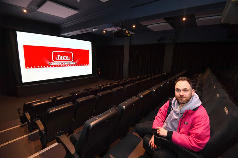 Andy Harrison sat in a row of seats at the Bijou Cinema with the film screen behind him