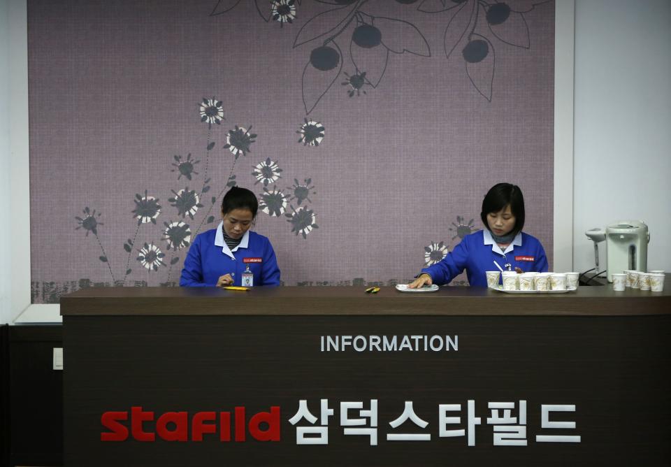 North Korean employees prepare to greet officials from the G20 Seoul Conference at a factory of a South Korean company at the Joint Industrial Park in Kaesong, a few miles inside North Korea from the heavily fortified border December 19, 2013. North Korea hosted a group of foreign officials and journalists on Thursday in a rare opening of the industrial zone jointly run with the South, a week after the regime executed the powerful uncle of leader Kim Jong Un. North and South Korean officials also held meetings at the Kaesong complex on Thursday to discuss the operations of the factory park, their first contact since the purge of Jang Song Thaek, considered the second-most powerful man in the country. REUTERS/Kim Hong-Ji (NORTH KOREA - Tags: BUSINESS EMPLOYMENT POLITICS)