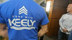 A Keely supporter wears a blue and white t-shirt that reads “STAND WITH KEELY MICHIGAN STATE POLICE.”