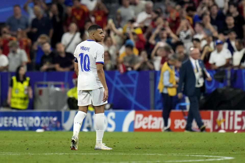 Kylian Mbappe of France stands on the pitch after a semifinal match between Spain and France at the Euro 2024 soccer tournament in Munich, Germany, Tuesday, July 9, 2024. Left Spain's Rodri. (AP Photo/Hassan Ammar)