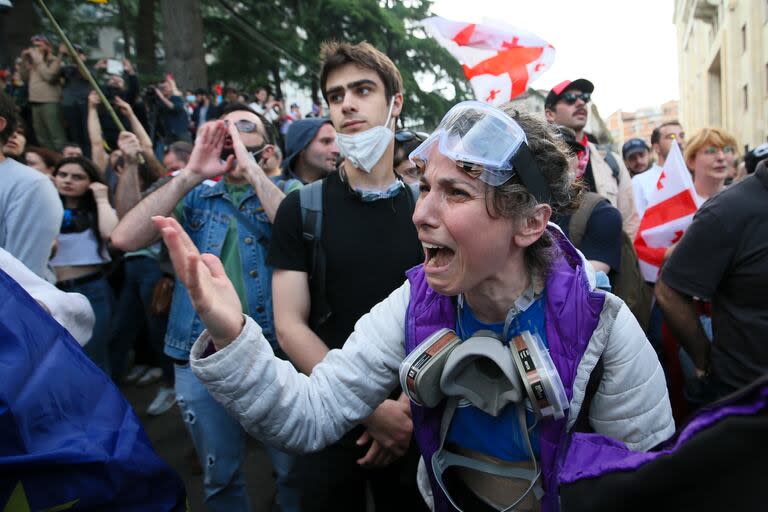 Una manifestante discute con policías durante una protesta opositora contra una ley sobre influencia extranjera ante el edificio del Parlamento en Tiflis, Georgia, el martes 28 de mayo de 2024. (AP Foto/Zurab Tsertsvadze)