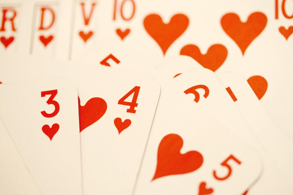 a spread out deck of cards with a focus on the four of hearts