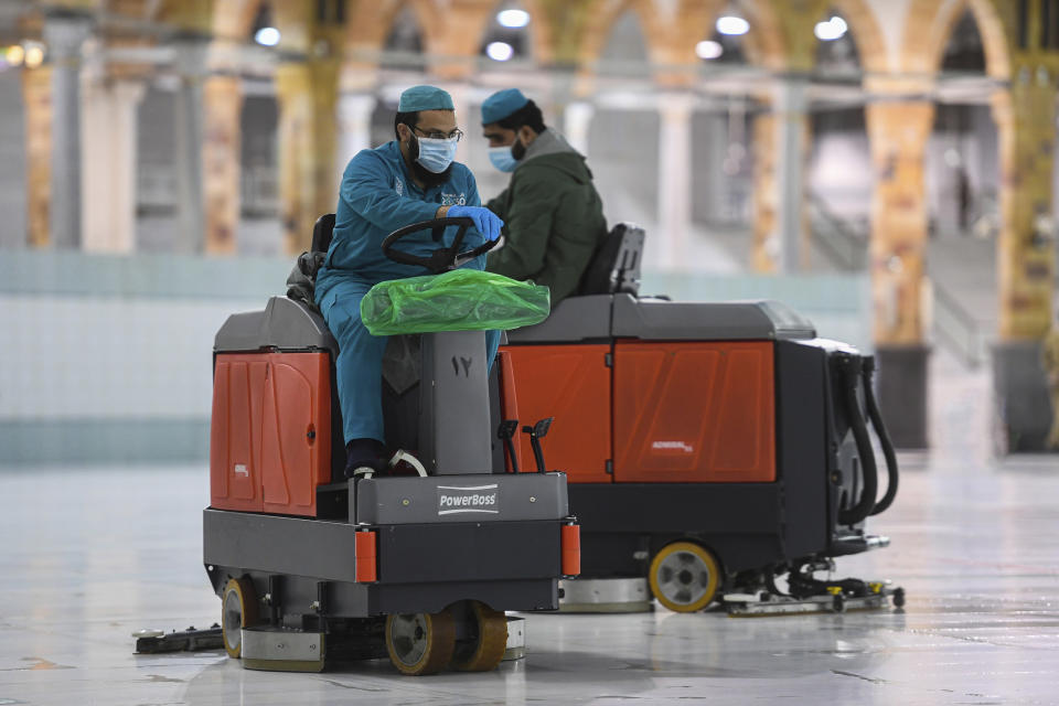 In this photo released by the Saudi Media Ministry, workers polish the white marble floors surrounding Islam’s holiest site, the Kaaba, inside the Grand Mosque in Mecca, Saudi Arabia, July 29, 2020, ahead of the arrival of as little as 1,000 pilgrims for this year’s downsized hajj pilgrimage. This year’s much smaller pilgrimage is taking place amid a global coronavirus pandemic. (Saudi Media Ministry via AP)