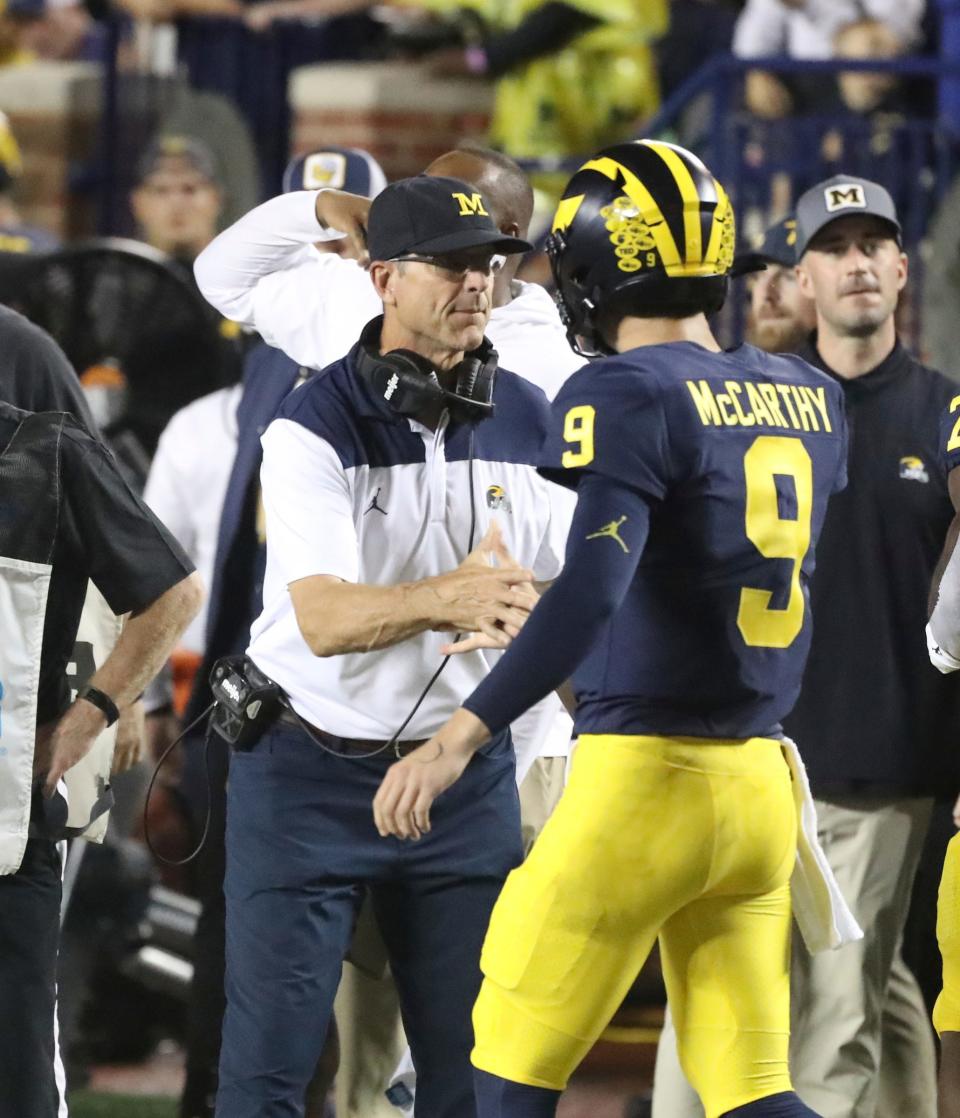 Michigan Wolverines quarterback J.J. McCarthy (9) and head coach Jim Harbaugh talk on the sidelines against the Hawaii Rainbow Warriors during first-half action at Michigan Stadium in Ann Arbor on Saturday, Sept. 10, 2022.
