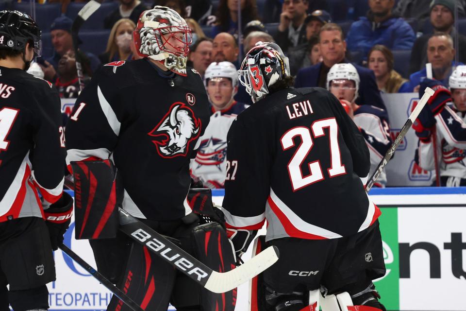 Buffalo Sabres goaltender Ukko-Pekka Luukkonen (1) enters the team's NHL hockey game as goaltender Devon Levi (27) is pulled during the second period against the Columbus Blue Jackets on Tuesday, Dec. 19, 2023, in Buffalo, N.Y. (AP Photo/Jeffrey T. Barnes)