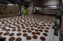 A worker inspects biscuits on the production line of Pladis' McVities factory in London Britain, September 19, 2017. Picture taken September 19, 2017. REUTERS/Peter Nicholls.