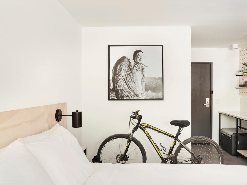 Inside a Field Station hotel room with a bed, furniture, bike