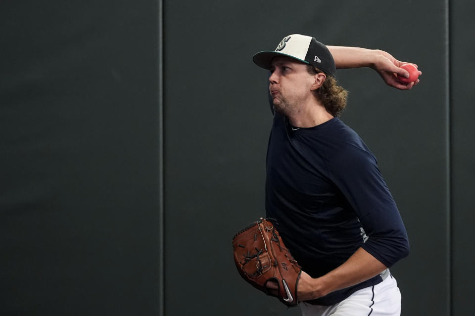 Seattle Mariners pitcher Logan Gilbert warms up with a weighted ball before a baseball game against the Minnesota Twins, Sunday, June 30, 2024, in Seattle. Velocity training is the rage in baseball from the youth levels up through the majors. Players go through specialized programs – often using series of progressively weighted baseballs – in the hopes of speeding up their bodies and arms, pushing them to the limits of what might be possible for their age and ability. (AP Photo/Lindsey Wasson)