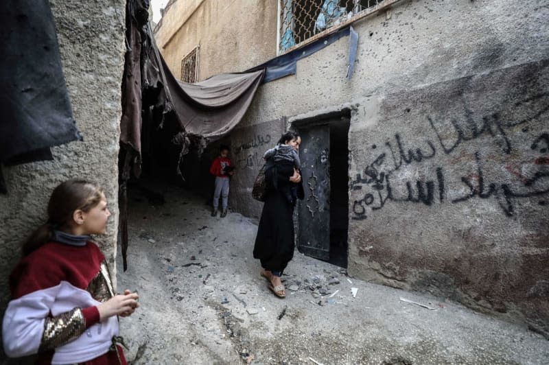 People look at the site of the bombing after an Israeli drone attack in the Jenin camp in the West Bank. Three people have been killed in Israeli army operations overnight in Jenin in the West Bank, the Israeli army reported. Ayman Nobani/dpa