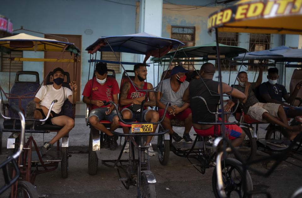 Bicycle taxi drivers sit on their bikes as they wait for customers in Old Havana, Cuba, Monday, July 12, 2021, the day after protests against food shortages and high prices amid the coronavirus crisis. (AP Photo/Eliana Aponte)
