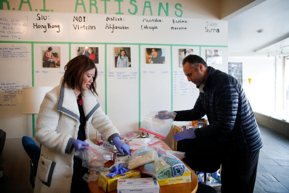 Founder Ming-Ming Tung-Edelman works to bag supplies for masks with a volunteer who will deliver them to individual homes for production at Refugee Artisan Initiative, an organization employing refugee and immigrant women that has shifted to making masks and other protective equipment for healthcare workers during the coronavirus disease (COVID-19) outbreak in Seattle, Washington, U.S. March 24, 2020. REUTERS/Lindsey Wasson