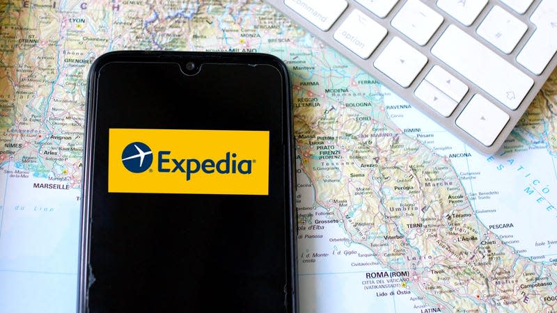 Expedia application on a smartphone screen lying on the world map