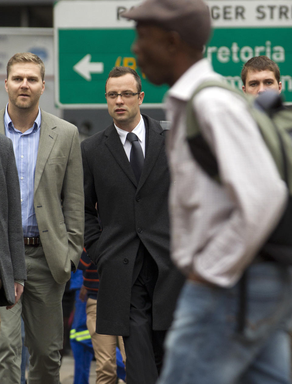 Oscar Pistorius, second from left, accompanied by unidentified men arrives at the high court for his murder trial in Pretoria, South Africa, Tuesday, March 11, 2014. Pistorius is charged with murder for the shooting death of his girlfriend, Reeva Steenkamp, on Valentines Day in 2013. (AP Photo/Themba Hadebe)