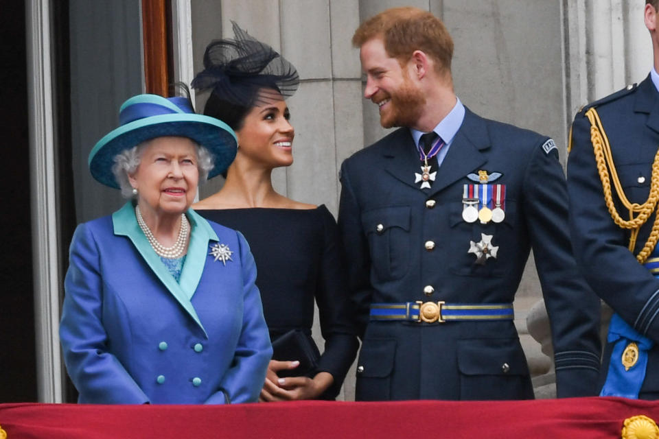 Queen Elizabeth ll, Meghan, Duchess of Sussex and Prince Harry, Duke of Sussex stand on the balcony of Buckingham Palace to mark the centenary of the Royal Air Force. (Photo: Anwar Hussein via Getty Images)