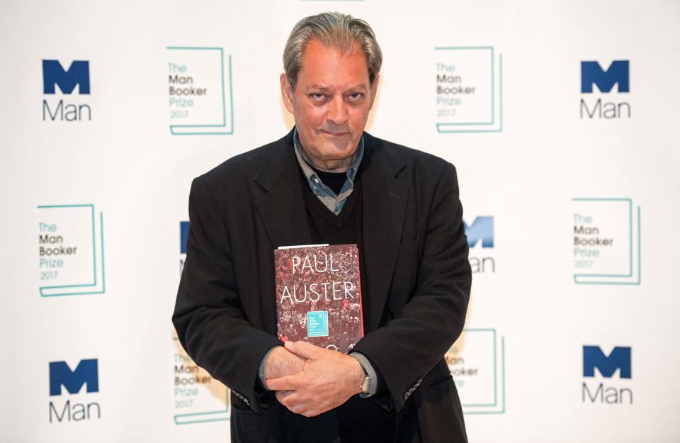 Paul Auster holds his book "4321" during a photocall at the Royal Festival Hall in London on Oct. 16, 2017.