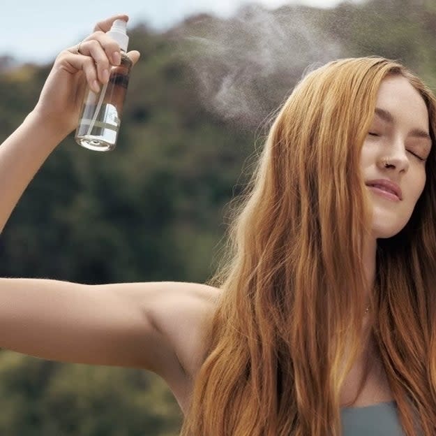 model spraying mist onto hair