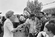 Then-first lady Pat Nixon reaches from San Diego across the border - then marked by a barbed wire fence - to greet people on the Tijuana, Mexico side during the dedication of Friendship Park on Aug. 18, 1971. In the days before Joe Biden became president, construction crews worked quickly to finish Donald Trump's wall at an iconic cross-border park overlooking the Pacific Ocean that then-first lady Pat Nixon inaugurated in 1971 as symbol of international friendship. Biden on Wednesday, Jan. 20, 2021 ordered a "pause" on all wall construction within a week, one of 17 executive edicts issued on his first day in office, including six dealing with immigration. (Richard Nixon Presidential Library and Museum via AP)