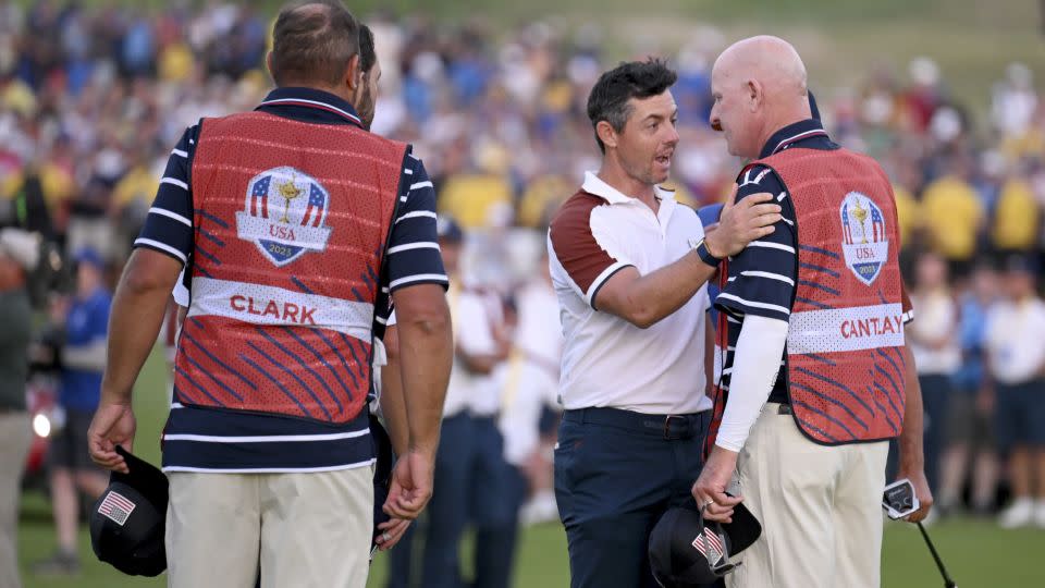 McIlroy speaks with LaCava after losing to Cantlay. - Ross Kinnaird/Getty Images