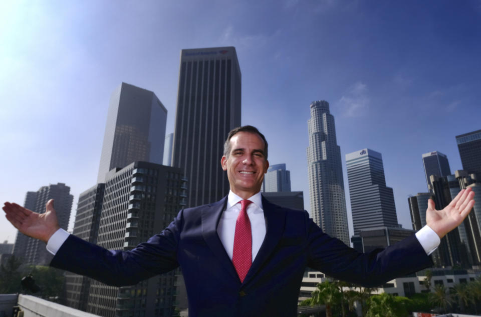FILE - In this Aug. 23, 2018, file photo, Los Angeles Mayor Eric Garcetti poses for a photo in front of a sprawling downtown Los Angeles landscape. The Democratic mayor, who has said he will soon decide whether to enter the 2020 White House contest, would anchor his candidacy to the idea that local government is where things get done in America, in contrast to the turmoil and vast political divide in President Donald Trump's Washington. (AP Photo/Richard Vogel, File)