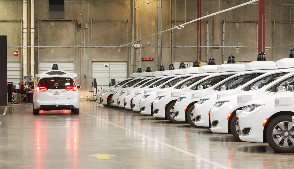 Waymo self-driving minivans in a warehouse.