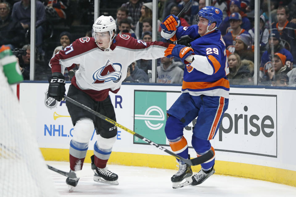 Colorado Avalanche defenseman Ryan Graves (27) fends off New York Islanders center Brock Nelson (29) during the second period of an NHL hockey game, Monday, Jan. 6, 2020, in Uniondale, N.Y. (AP Photo/Kathy Willens)