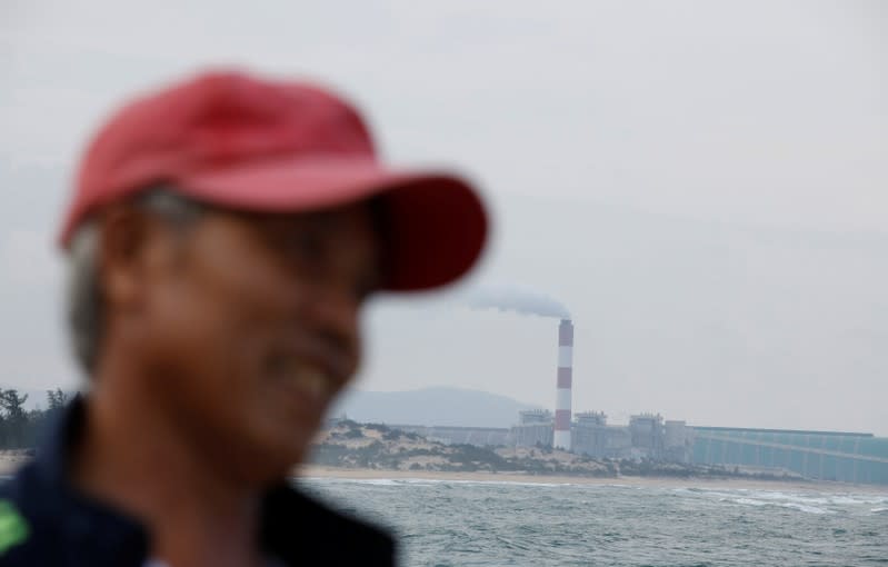 A fisherman walks past Formosa steel mill in Ha Tinh province