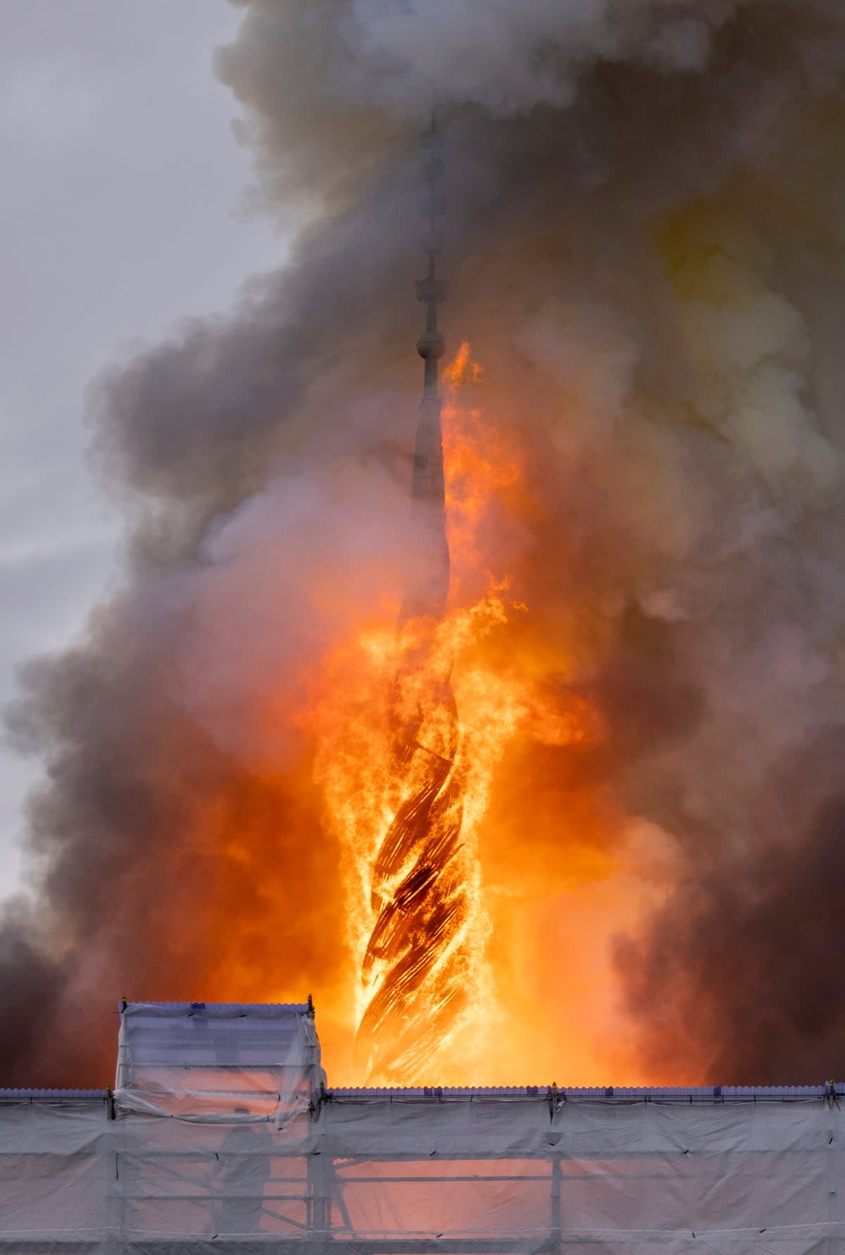 Flames wrap around the dragon spire (EPA)