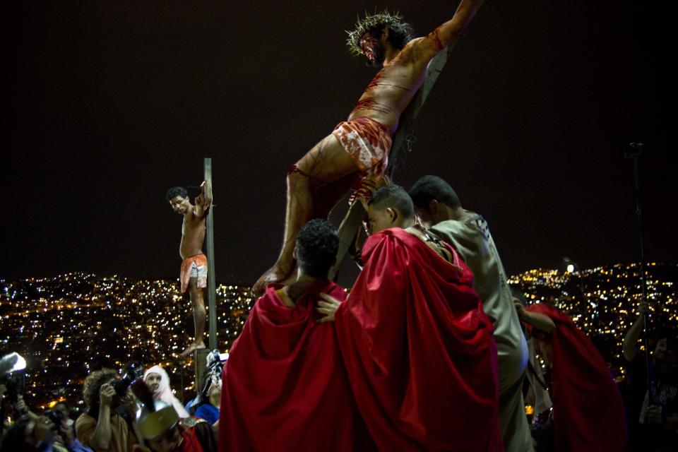 Residents reenact Jesus Christ's crucifixion on a hilltop in the Petare shanty town during Holy Week in Caracas, Venezuela, Friday, April 18, 2014. Holy Week commemorates the last week of the earthly life of Jesus culminating in his crucifixion on Good Friday and his resurrection on Easter Sunday. (AP Photo/Ramon Espinosa)