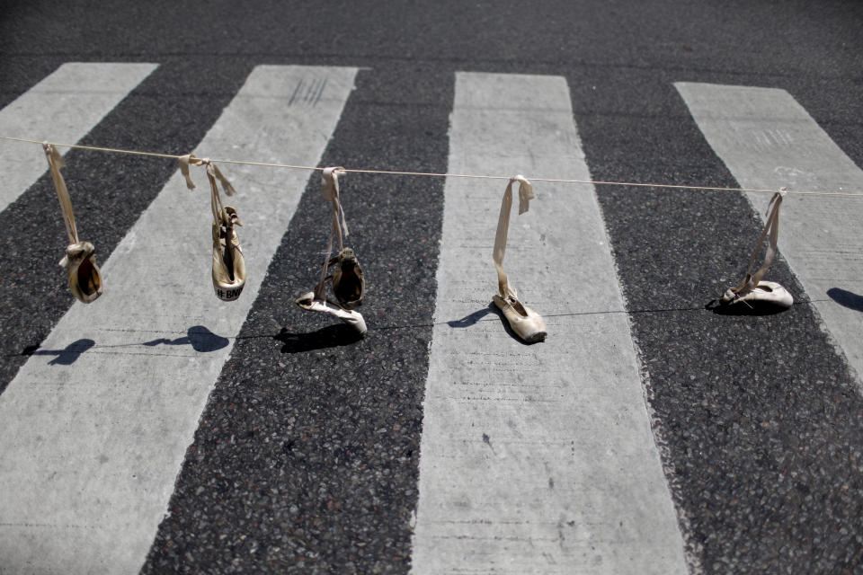 <p>An einem Seil hängende Ballettschuhe über einem Zebrastreifen in Buenos Aires, Argentinien. Es ist eine stille Form des Protestes gegen die kürzlich erfolgte Entscheidung, die Förderung der staatlichen Tanzensembles zu kürzen. Ungefähr 80 Tänzer, Choreographen und andere Mitarbeiter am „National Ballet of the Dance“ verloren im Dezember ihren Arbeitsplatz wegen Sparmaßnahmen der Regierung. (Bild: AP Photo/Natacha Pisarenko) </p>