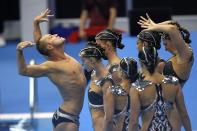 Bill May, left, leads the United States team out to compete in the team acrobatic of artistic swimming at the World Swimming Championships in Fukuoka, Japan, Saturday, July 15, 2023. Largely unoticed by the general public, men have been participating in artistic swimming, formerly known as synchronized swimming, for decades. (AP Photo/David J. Phillip)