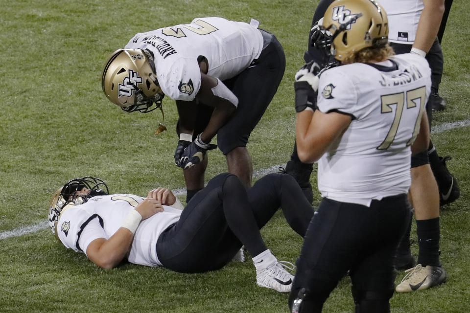 UCF quarterback Dillon Gabriel (11) lies on the field with an apparent injury during the first half of the team's NCAA college football game against Cincinnati, Friday, Oct. 4, 2019, in Cincinnati. (AP Photo/John Minchillo)