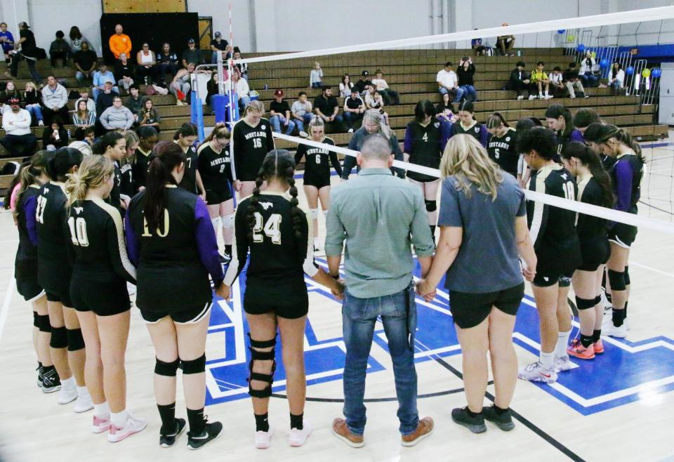 Lucerne Valley High School Lady Mustangs’ volleyball players and coaches lead a moment of silence for Kristy Klaus and Kayden Davis, both 16, who died last year.