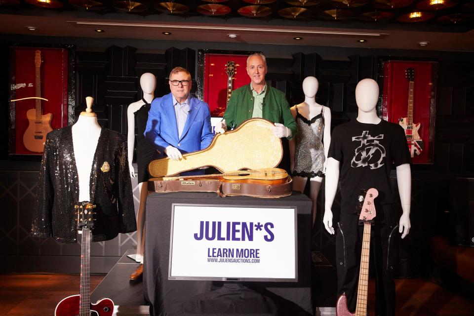 Julien's Auctions co-founders Darren Julien and Martin Nolan alongside John Lennon's guitar, at Hard Rock Cafe in London's Piccadilly Circus.