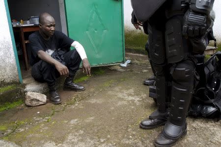 An injured member of Guinea's security forces sits at a clinic of Bambeto as they clashed with protesters after opposition candidates called on Monday for the results of the election to be scrapped due to fraud, in Conakry October 13, 2015. REUTERS/Luc Gnago