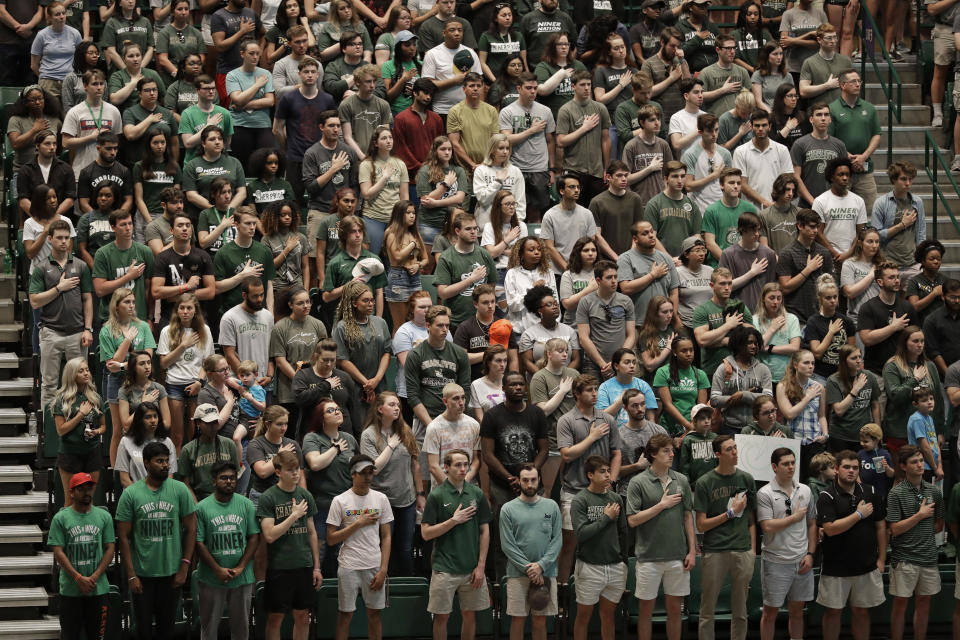 Students stand in Halton Arena during a vigil at the University of North Carolina-Charlotte in Charlotte, N.C., Wednesday, May 1, 2019 after a student with a pistol killed two people and wounded four others on Tuesday. (AP Photo/Chuck Burton)
