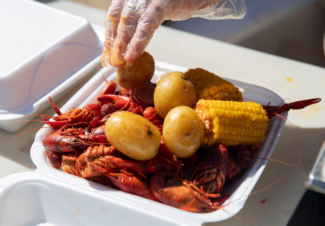 Customers eat crawfish, shrimp, sausage, potatoes and corn Saturday, Feb. 19, 2022, at Max's Sports Bar.
