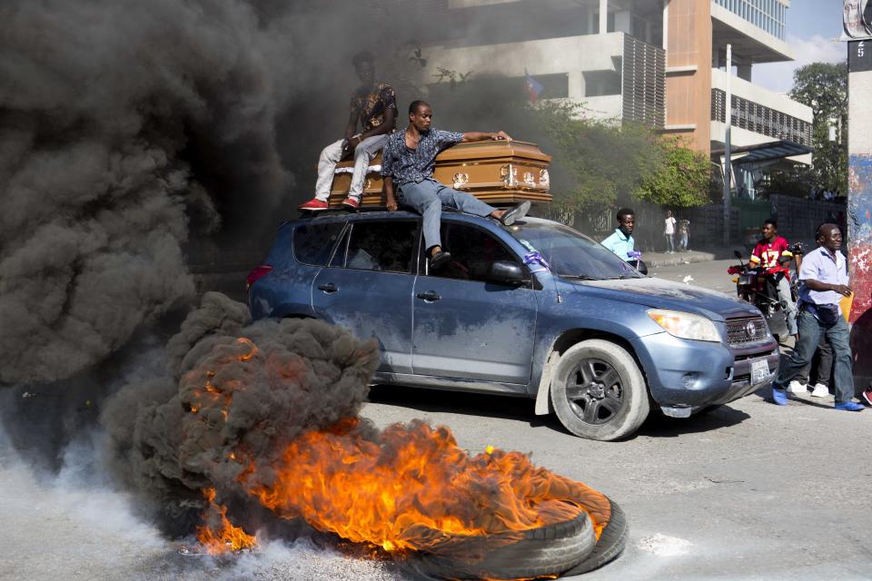 FILE - In this March 4, 2019 file photo, men accompany a coffin containing the remains a demonstrator who was killed in a previous protest, in Port-au-Prince, Haiti. The country's largest opposition groups have united in a campaign to push U.S.-backed President Jovenel Moise from office with nationwide protests aimed at paralyzing the country starting on Friday, March 29, 2019. (AP Photo/Dieu Nalio Chery, File)