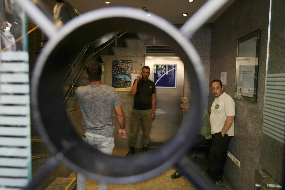 Security men gather at the entrance of BLOM bank branch where a man who is identified as Abed Soubra is allegedly holding hostages in an effort to get to funds in his account in Beirut, Lebanon, Friday, Sept. 16, 2022. Depositors broke into at least four banks in different parts of crisis-hit Lebanon Friday demanding that they get their trapped savings as chaos spreads in the small Mediterranean nation in the middle of a historic economic meltdown. (AP Photo/Bilal Hussein)