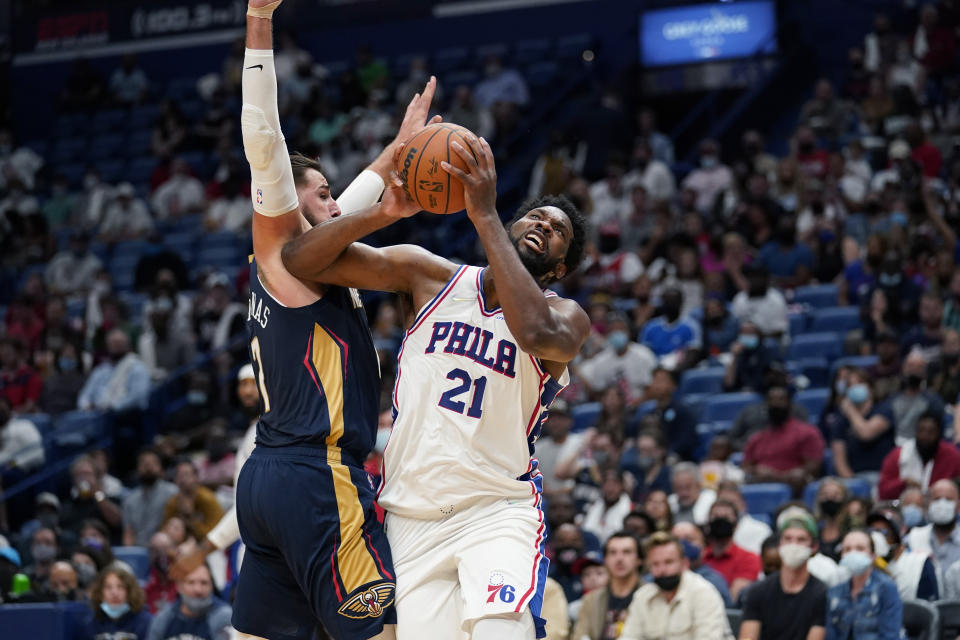 Philadelphia 76ers center Joel Embiid (21) goes to the basket against New Orleans Pelicans center Jonas Valanciunas in the first half of an NBA basketball game in New Orleans, Wednesday, Oct. 20, 2021. (AP Photo/Gerald Herbert)