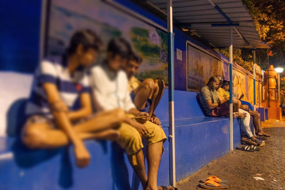 Locals sit outdoors in Alambajar, Kolkata.