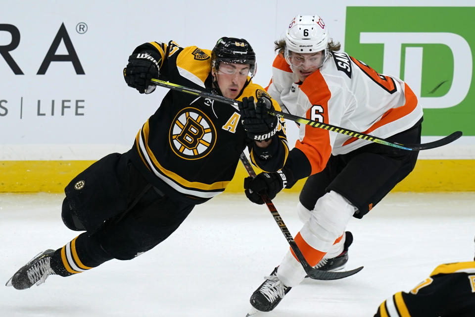 Boston Bruins center Brad Marchand (63) and Philadelphia Flyers defenseman Travis Sanheim (6) skate for position during the third period of an NHL hockey game Thursday, Jan. 21, 2021, in Boston. (AP Photo/Elise Amendola)