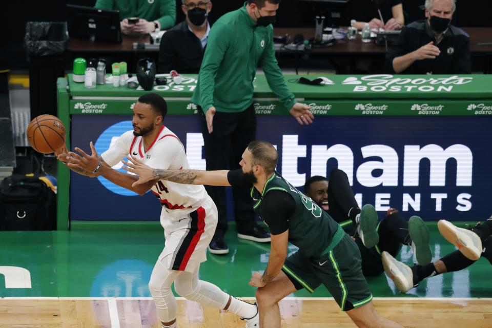 Boston Celtics' Evan Fournier (94) defends against Portland Trail Blazers' Norman Powell (24) as Boston Celtics' Jaylen Brown, behind right, collides with Jayson Tatum, far right, as head coach Brad Stevens reacts during the second half of an NBA basketball game, Sunday, May 2, 2021, in Boston. (AP Photo/Michael Dwyer)