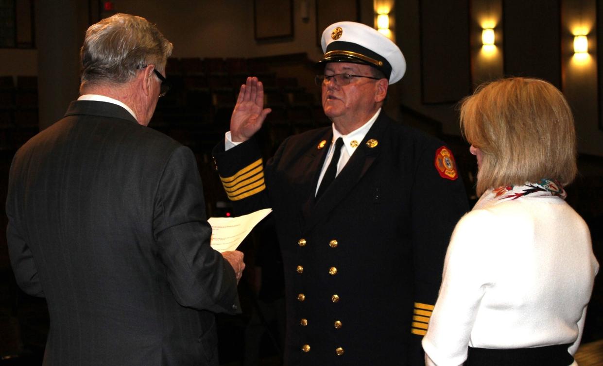 Cranston Mayor Kenneth J. Hopkins, left, administers an oath to Cranston Fire Chief Robert J. Ryan, center, at a swearing in ceremony on Tuesday.