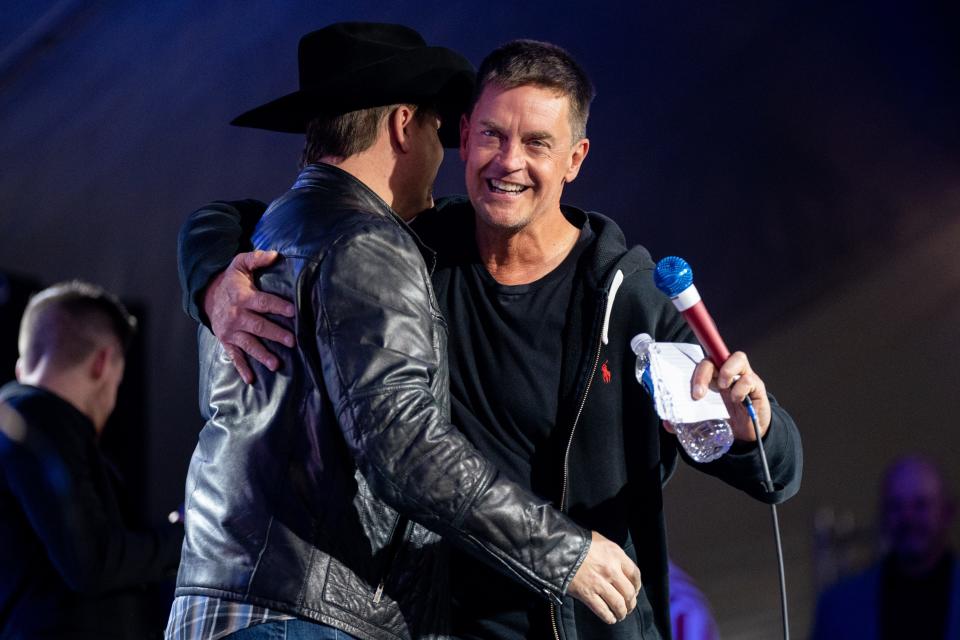 Comedian Jim Breuer, right, hugs musician John Rich, left, on stage during the ReAwaken America Tour at Global Vision Bible Church in Mt. Juliet, Tenn., Friday, Jan. 20, 2023.