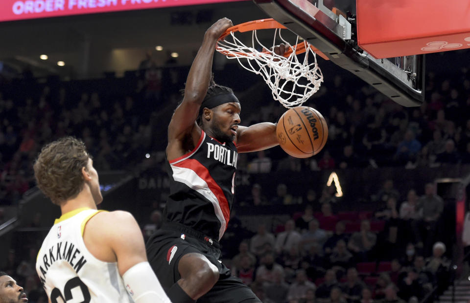 Portland Trail Blazers forward Jerami Grant, right, dunks the ball on Utah Jazz forward Lauri Markkanen, left, during the first half of an NBA basketball game in Portland, Ore., Wednesday, Jan. 25, 2023. (AP Photo/Steve Dykes)