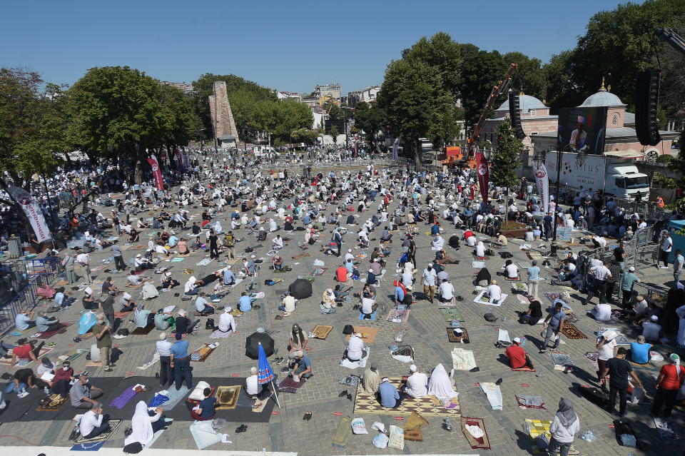 Faithful wait at the historic Sultanahmet district of Istanbul, near the Byzantine-era Hagia Sophia, Friday, July 24, 2020. Hundreds of Muslim faithful were making their way to Istanbul's landmark monument Friday to take part in the first prayers in 86 years at the structure that was once Christendom's most significant cathedral and the "jewel" of the Byzantine Empire then a mosque and museum before its re-conversion into a Muslim place of worship. The conversion of the edifice, has led to an international outcry. (AP Photo/Yasin Akgul)